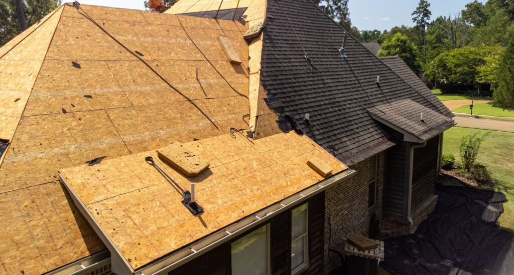 Roof replacement in progress with new decking installed after tear-off
