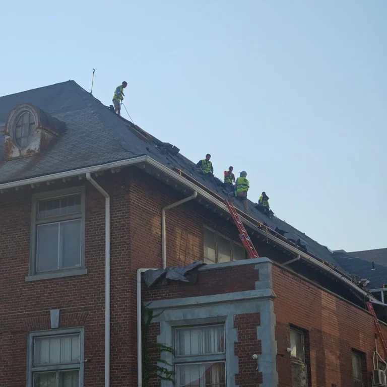 Roofing crew working on a large brick building – T&M Roofing project