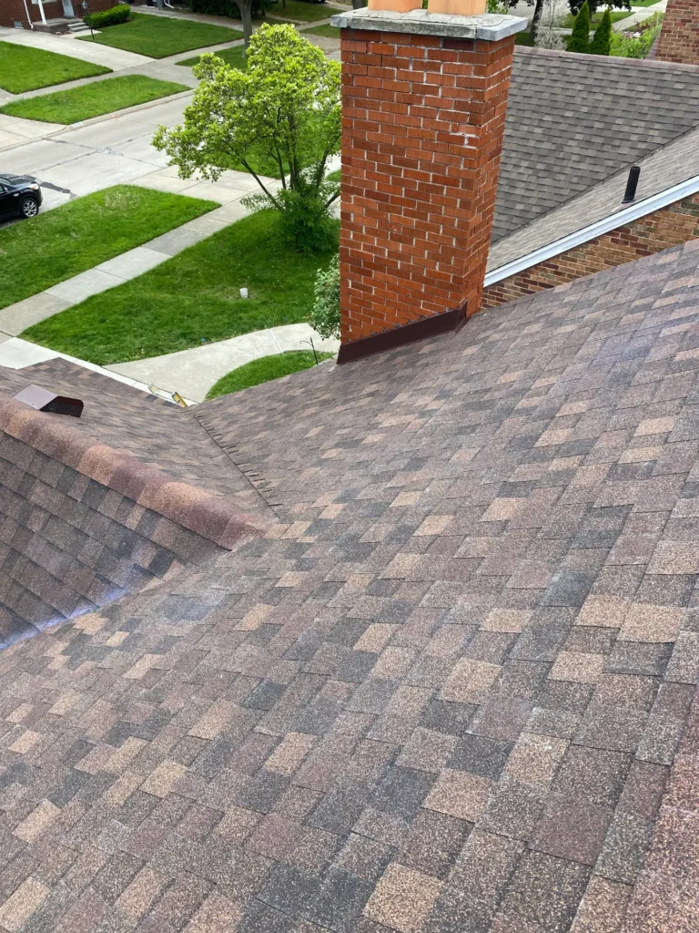 Roofer nailing new asphalt shingles with