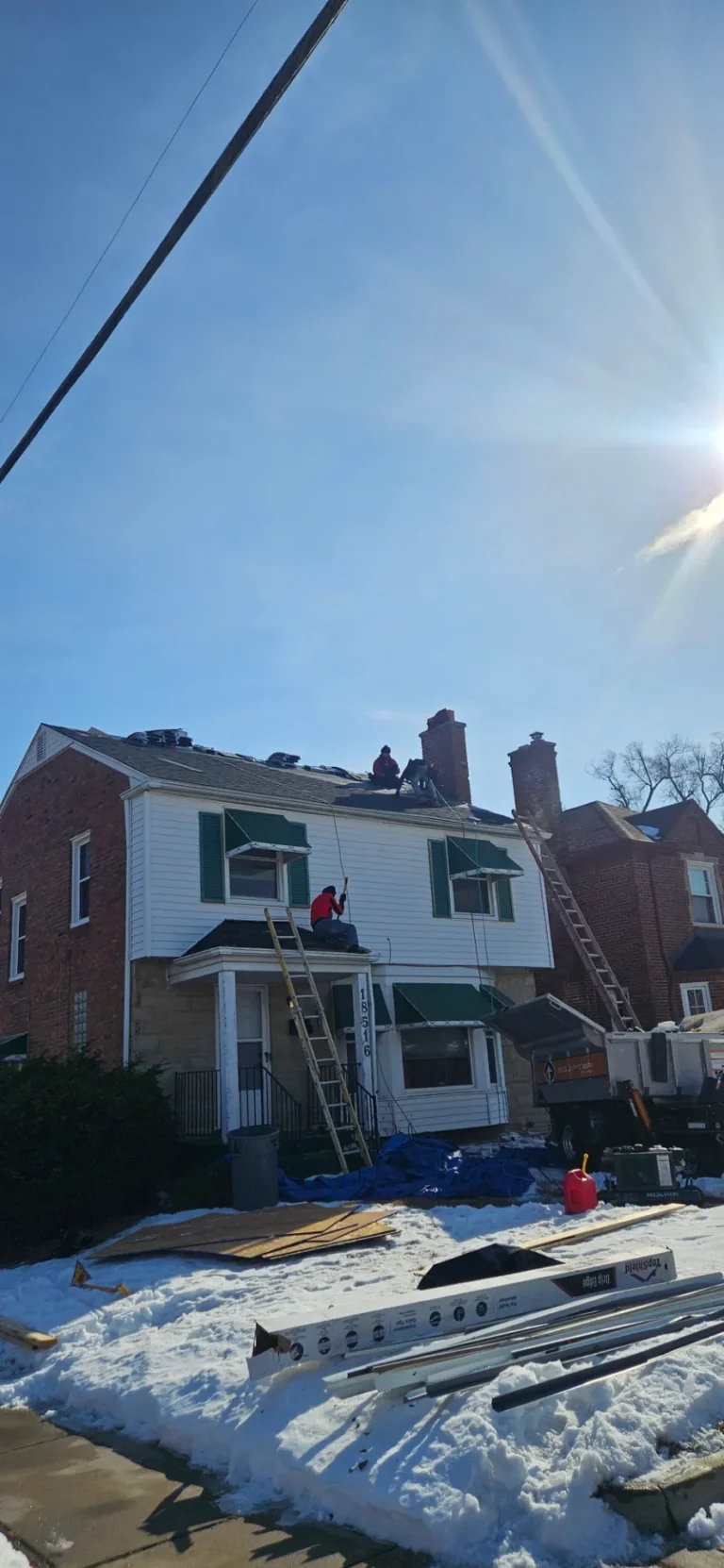 T&M Roofing crew working on a colonial home roof