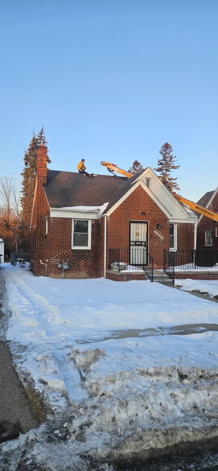 T&M Roofing winter roof replacement on a brick home using a lift